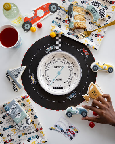 Race car-themed table setup with speedometer plates and raceway placemats