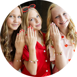 Playful charm-bracelet motifs, soft reds, pinks & creams.